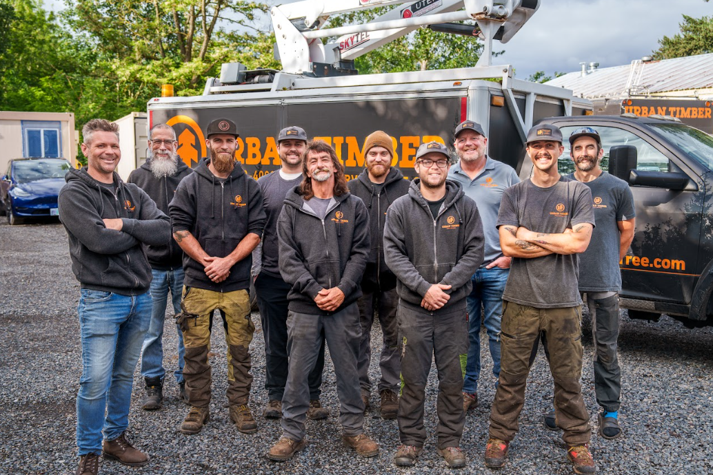 Group photo of Urban Timber tree service crew standing in front of their work truck.